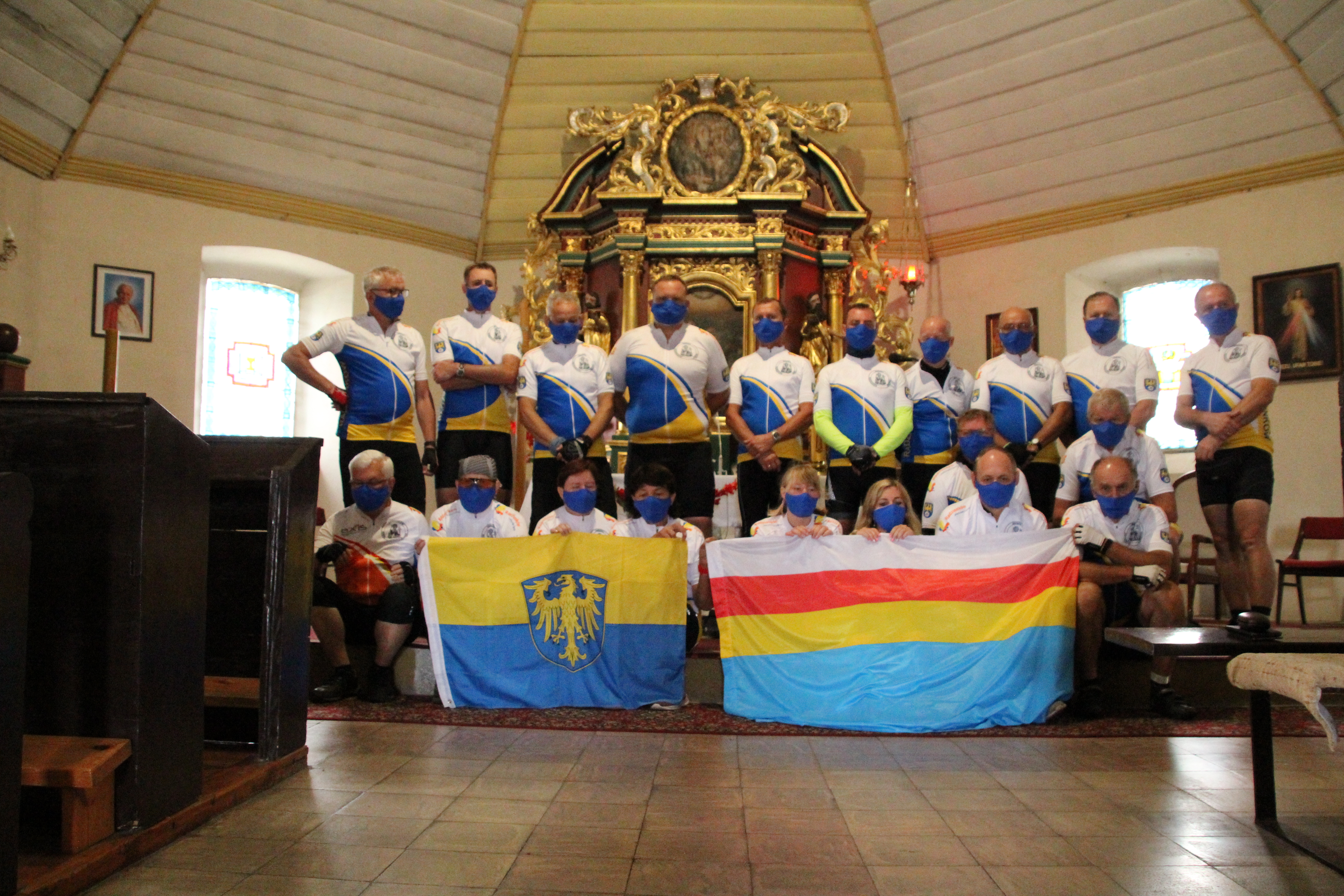 Grupa w kościele trzymająca flagę Górnego Śląska i Radzionkowa